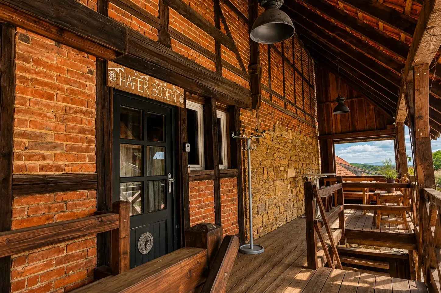 Eingang des Haferbodens mit Schild, Backstein-Fachwerkfassade und überdachter Holzterrasse